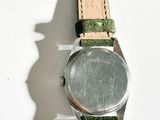 a close up of a watch on a white surface