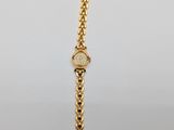 a close up of a gold bracelet with a diamond on it