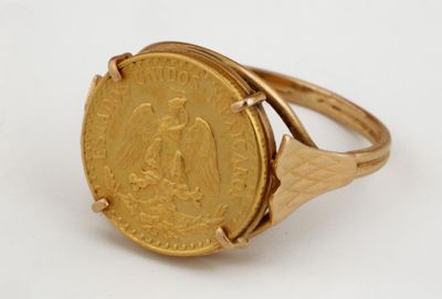l'image d'une bague en or sur laquelle se trouve une pièce de monnaie