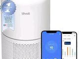 un gros plan d'un purificateur d'air connecté à côté d'un iPhone