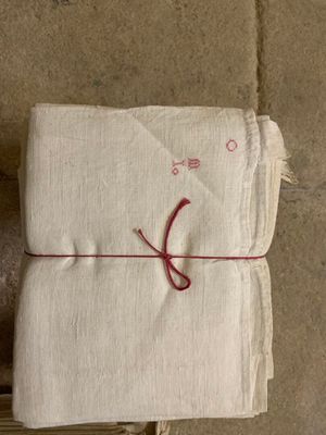 une pile de serviettes blanches entourées d'un fil rouge