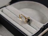a gold ring with a black stone in it in a box
