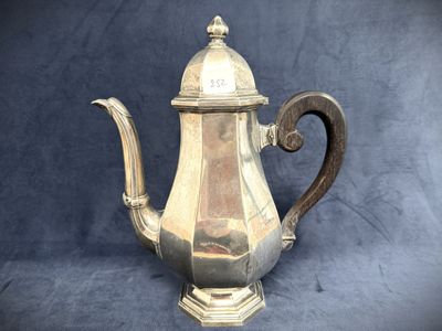 an antique silver tea pot with a wooden handle on a blue background