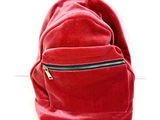 un sac à dos rouge posé sur une surface blanche