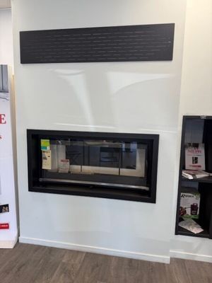 a fireplace in the middle of a room with a tv on the wall