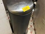 a trash can in the corner of a kitchen with a yellow tag on it
