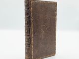 an old book sitting on top of a white surface