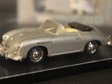 a silver toy car on display in a glass case