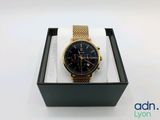 a close up of a watch in a box on a white surface