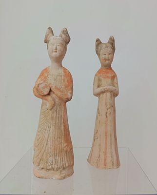 two figurines that are sitting on a glass table