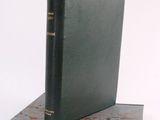 an old book sitting on top of a book stand on top of a marble block