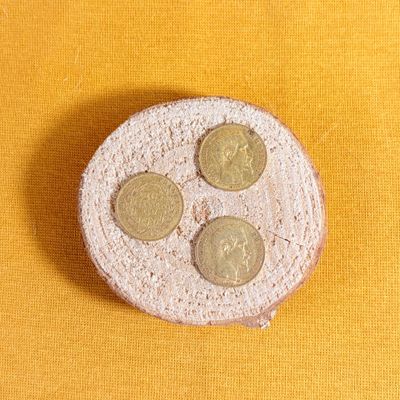 four coins sitting on a piece of bread on a yellow surface