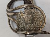 a silver sword with a metal handle on a white surface