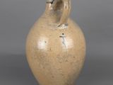 a brown vase with a handle on a gray background