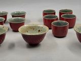 plusieurs bols et tasses rouges et verts posés sur une surface blanche