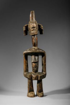 une sculpture en bois représentant un homme avec un visage sur la tête