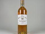 the bottle of wine is sitting on a white surface