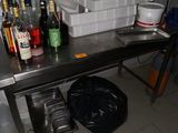 a table with a lot of bottles on it in a kitchen