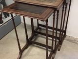 Dans une pièce, trois tables en bois sont empilées les unes sur les autres.