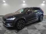 un SUV Volvo gris garé sur un sol à damier dans un showroom