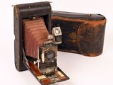 an old photo of an old camera with a leather case