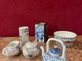 une table sur laquelle sont disposées diverses théières et tasses