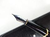a fountain pen sitting on top of a black case