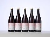 three bottles of wine sit side by side on a table