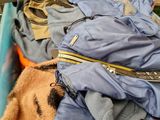 a pile of clothes and a teddy bear in a store