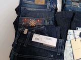 several pairs of men ' s jeans stacked on top of each other