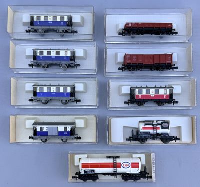 several different types of train cars are displayed in a display case