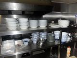 beaucoup d'assiettes et de bols sur les étagères de la cuisine