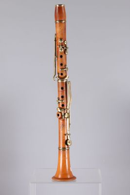 a close up of a wooden clarinet on a clear stand