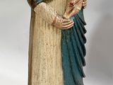 statue en bois d'une femme tenant un enfant dans ses bras