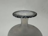 a white vase with a black and white design on it