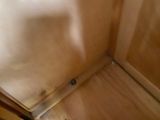 a close up of a wooden cabinet with a door open