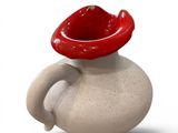 a small vase with a red hat on top of it