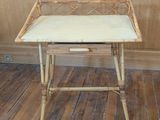 a small wooden table with a white top on a wooden floor