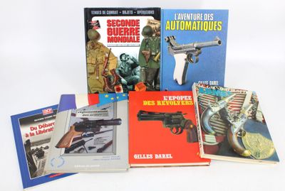 several books on a white surface with a gun and a gun