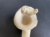 a white vase with a bird on it on a table