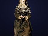 une statue représentant une femme vêtue d'une robe noire et ornée d'étoiles sur la tête