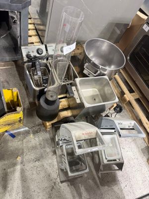 a pile of kitchen appliances and appliances on a pallet in a warehouse