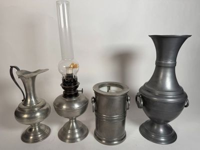 three different types of silver vases and a candle