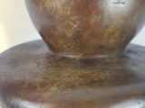 a bronze sculpture of a cat ' s head on top of a bowl