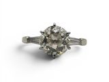 a close up of a diamond ring on a white surface
