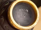 a black vase with a gold rim sitting on a table