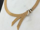 un gros plan d'un collier posé sur une surface en marbre