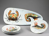 quatre assiettes ornées de motifs différents, posées sur un fond gris