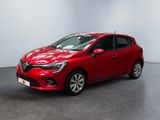 Une voiture rouge est garée dans une pièce aux murs blancs
