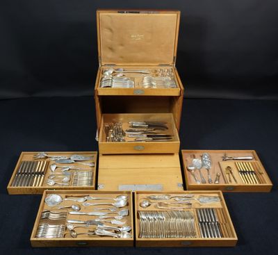 un assortiment d'argenterie dans un coffret en bois sur fond noir